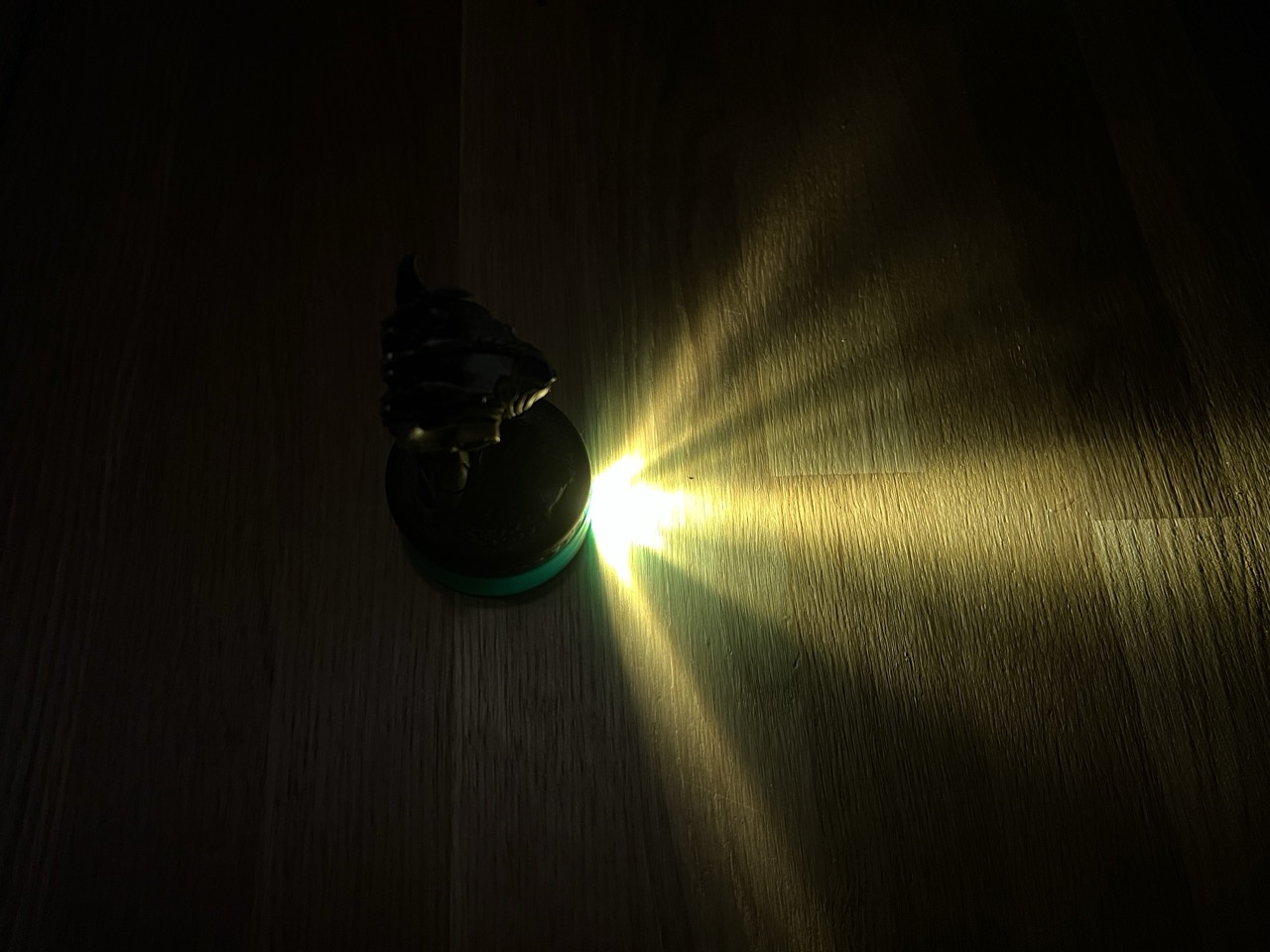 3D printed Beam Base projecting a wide field of view cone onto a tabletop, with an RPG miniature placed on top.