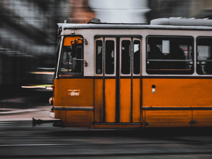 Yellow tram (urban rail transit train) moving fast from right to left